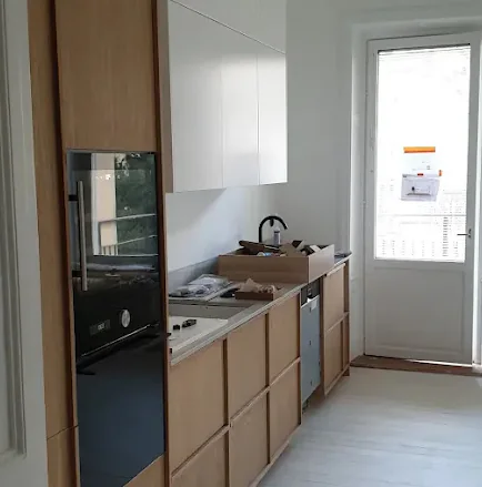 Pågående färdigställande med inbyggd förvaring, träfronter och ljus arbetsyta
